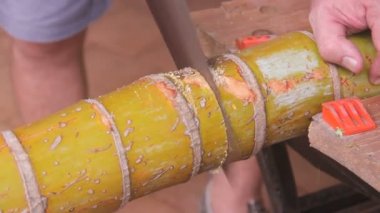 Olgun yaşlı tamirci bir el ile bir bambu kesme gördüm.