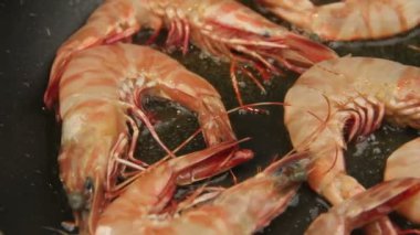 Bütün karides kızartma tavada kızgın yağ ile kızartılmış.