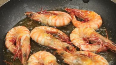 bir pişmiş ateşli demir tava koyun ahtapot bebek varlık ve üzerlerine dökülür varlık Marine ile cızırtılı.