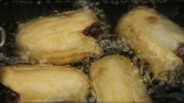 Basket of crisp golden dim sums cooking and bubbling in hot oil. — Stock Video
