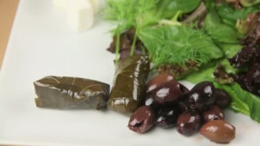 Dolmades veya beyaz peynir ve Yunan salatası ile servis dolma.