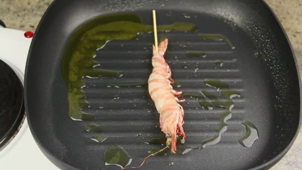 Whole shrimps sizzling in a chili marinade being turned with tongs in a fry pan. — Stock Video