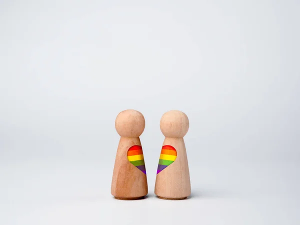Lgbtカップルのコンセプト スカートの形をした2つの木製の図形にハート型の虹のフラグは 一緒に白い背景に孤立立っている Lgbtプライドシンボル — ストック写真