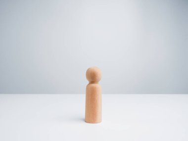 Beyaz arkaplanda tek başına duran tahta bir figür ve kopyalama alanı.