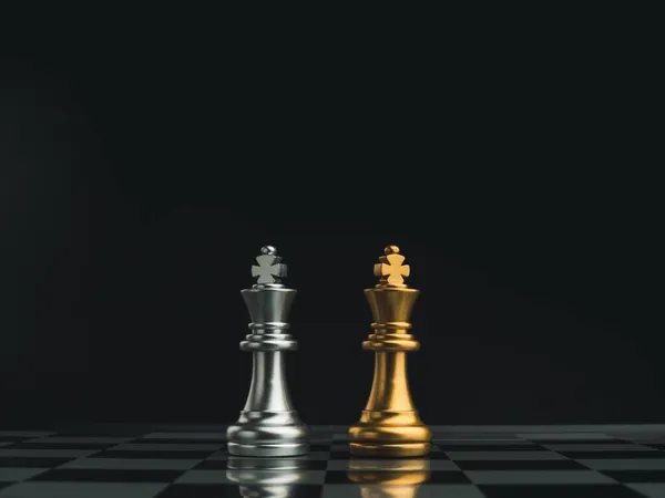 一个金色的国王棋子和一个银色的国王棋子在黑暗的背景下一起站在棋盘上 伙伴关系 竞争者 对抗和商业战略概念 — 图库照片