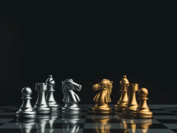 与一队金银财宝棋子 路克和棋子在黑暗背景的棋盘上对质 伙伴关系 竞争对手和业务战略概念 — 图库照片