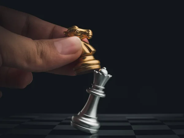 特写马 金骑士棋子攻击银后在棋盘上的黑暗背景 棋类比赛中的棋类移动手 管理和领导概念 — 图库照片