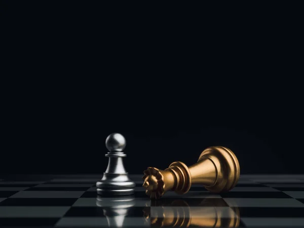 一只银色的棋子站在一块黑色背景的棋盘上 旁边是一只落下来的金色皇后棋子 勇敢的人 竞争和商业战略概念 — 图库照片