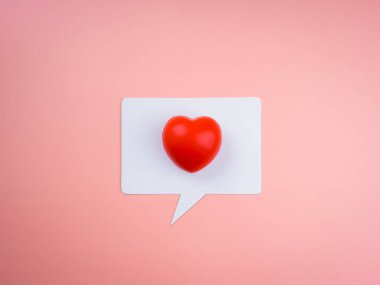 Beyaz konuşma balonunda kırmızı kalpli sosyal medya ikonu pembe pastel arka planda izole edilmiş. Genel sosyal medya bildirimleri sever. Aşk konsepti, asgari tarz.