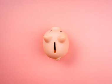 Pembe domuz kumbarası, pembe pastel arka planda izole edilmiş, üst manzara, minimal stil. Tasarruf ve iş yatırım kavramı.