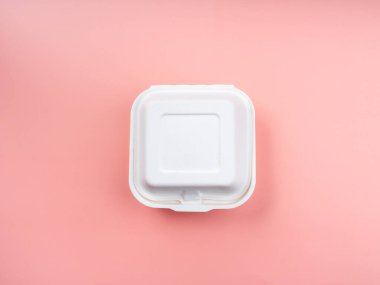 Çevre dostu ve yeşil alternatifler için geri dönüşümlü gıda konteynırları. Beyaz kare ağarmamış bitki fiber besin kutusu. Pembe arka planda izole edilmiş. Üst manzara..