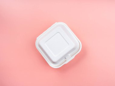 Pastel pembe arka planda izole edilmiş, beyazlatılmamış bitki lifli besin kutusu, üst manzara. Çevre dostu ve yeşil alternatifler için geri dönüşümlü ve biyolojik olarak bozunabilir gıda konteynırı kare şekli.