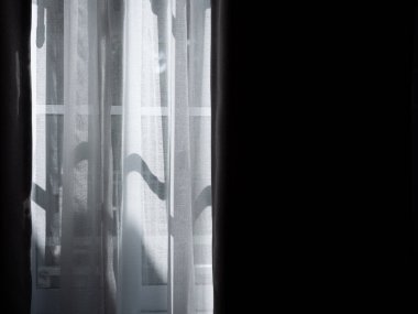 Karanlık odadaki pencerenin üzerindeki beyaz şeffaf perde ve fotokopi alanı. Perde iç dekorasyonu dışarıdan gelen ışıkla.