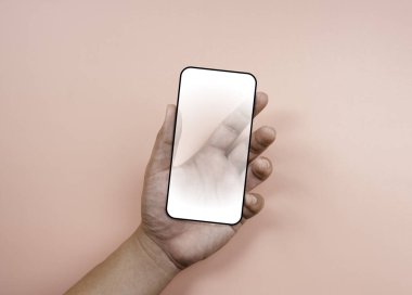Beyaz beyaz ekranlı, siyah çerçeveli, pastel pembe arka planda izole edilmiş bir akıllı telefon. Elinde şeffaf bir gelecek telefonu var, en düşük biçim.