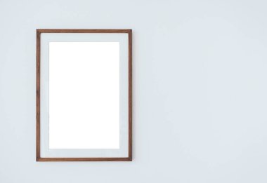 Mockup ahşap kare çerçeve montajlı, dikey stil, izole. İnce ahşap çerçeve üzerine boş beyaz. Beyaz arka planda asılı. Kopya alanı var..