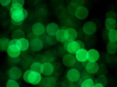 Siyah arkaplandaki güzel Bokeh 'in yeşil ışığın soyut bulanık görüntüsü. Bulanık şenlik, gece partisi ve geçmiş kutlamaları..