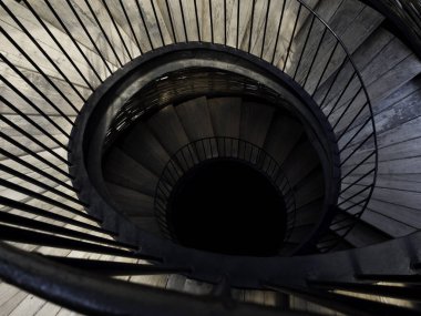 Spiral merdiven. Karanlığa giden ahşap ve demir sarmal merdiven görüntüsü..