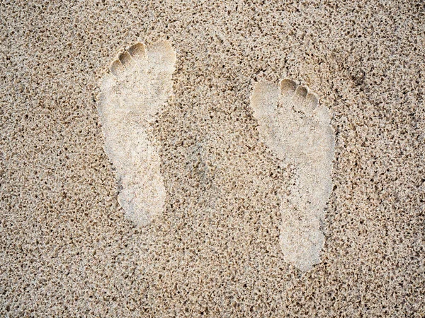 在沙滩背景下的特写脚印 人类脚迹上的湿沙质感 顶视图 假日和夏季的概念 — 图库照片
