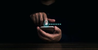 Lock icons and password hidden behind asterisks appear while man's finger touching on mobile phone on dark background. Cyber security, data protection, business privacy technology concept.
