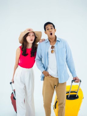 Birkaç gezgin, arkadaşlarla mutlu tatiller. Yaz tatili. Renkli kostümler içinde genç Asyalı bir adam ve kadın beyaz arka planda izole edilmiş heyecanlı yüzlü kameraya bakıyor..