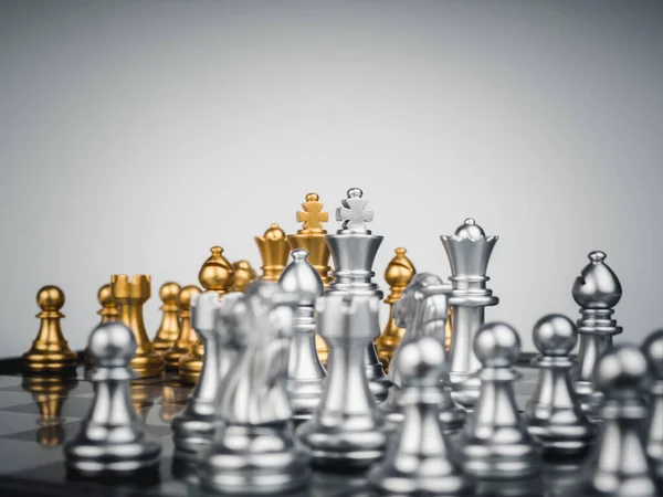 Set of gold and the silver chess pieces, king, rook, bishop, queen, knight, and pawn standing together on the chessboard. Leadership, fighter, competition, confrontation, and living together concept.