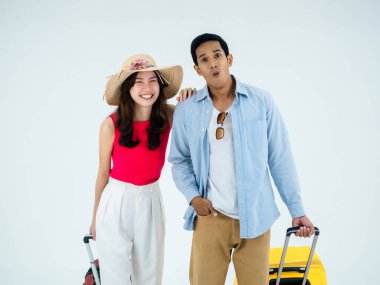 Birkaç gezgin, arkadaşlarla mutlu tatiller. Yaz tatili. Renkli kostümler içinde genç Asyalı bir adam ve kadın beyaz arka planda izole edilmiş heyecanlı ve neşeli yüzlü bir kameraya bakıyor..