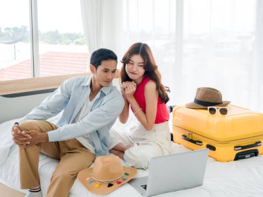 Kız arkadaşı yalvarıyor ve erkek arkadaşını yaz gezisine çıkmaya ikna ediyor. Genç ve yakışıklı Asyalı bir kadın ve yatak odasında bavuluyla dizüstü bilgisayara bakan yakışıklı bir adam. İyi tatiller..