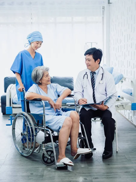 Senior Woman Patients Wheelchair Smile Male Surgeon Doctors Professional Female — Zdjęcie stockowe