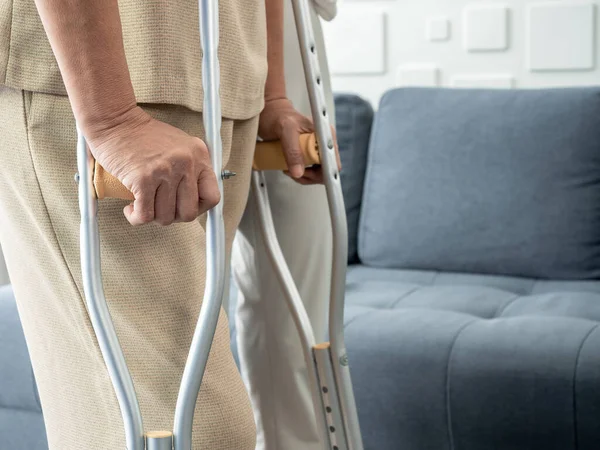Closeup Elderly Woman Hands Holding Crutches Standing Living Room Home — Zdjęcie stockowe