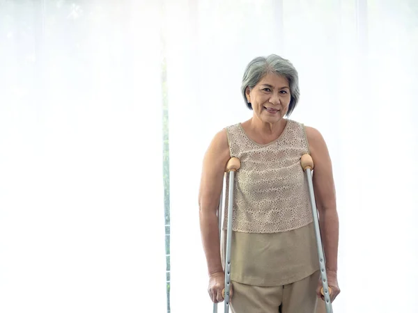 Asian Senior Woman White Hair Standing Crutches Curtain Copy Space — Fotografia de Stock