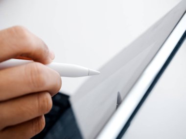 Close up white electronic pen or pencil in hand, write, draw or sign on blank digital tablet screen, computer isolated on white background. Business and technology concept. Working with tech device.