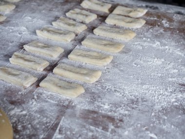 Kızarmış hamur çubukları için hammadde hazırlama ya da kızartmak için kaynar yağ atmadan önce buğday unuyla Patongko, Tayland 'da Asya' nın ünlü sokak yemekleri Çin çöreği tarzı..