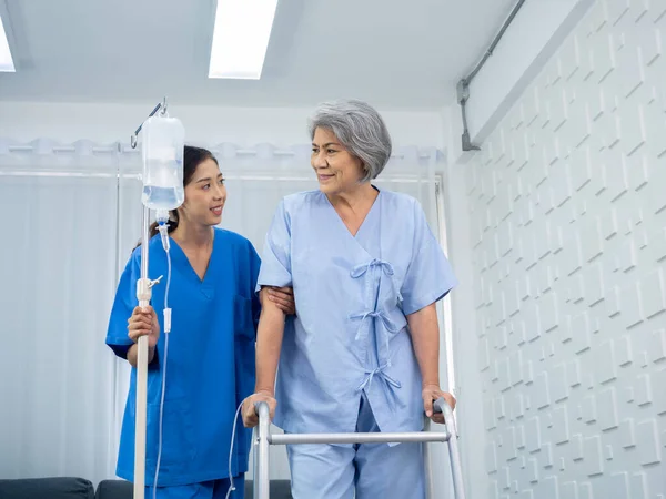 Elderly Asian Woman Patient Trying Walk Walking Frame Held Carefully — Zdjęcie stockowe