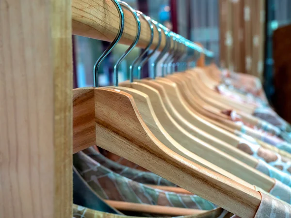 亚洲风格时装店木制衣架上挂着彩色衬衫的特写木制衣架 — 图库照片