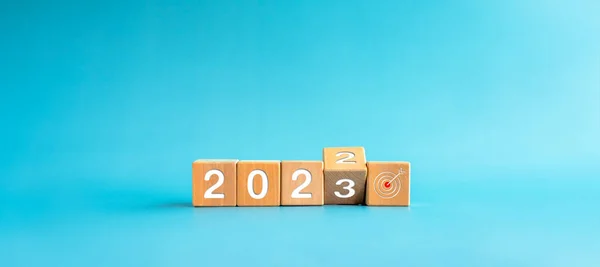 2022历年改为2023年 目标和成功的概念 从2022年向2023年过渡的木制立方体块 在蓝色横幅背景上隔离目标图标标志 — 图库照片