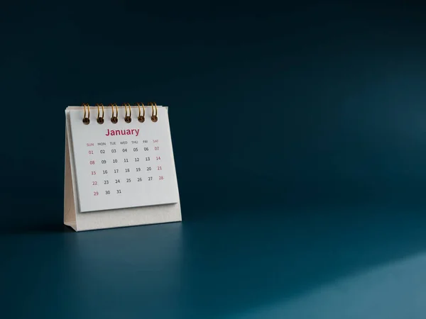 A January 2023 calendar desk for the organizer to plan and reminder isolated on blue background, minimal style with copy space. White small table calendar with first month page, Happy new year 2023.