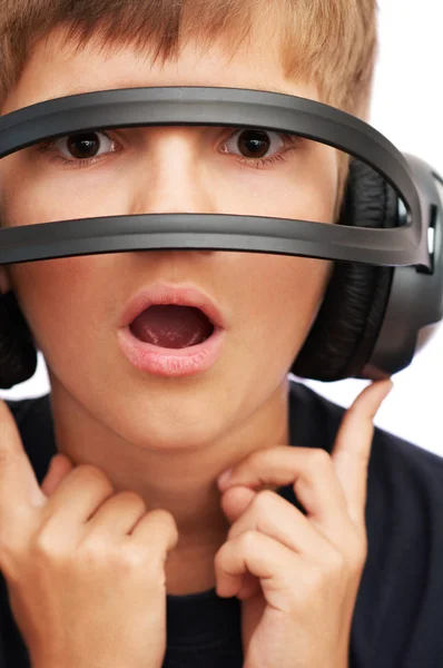 Chico sorprendido mirando a través de auriculares — Foto de Stock