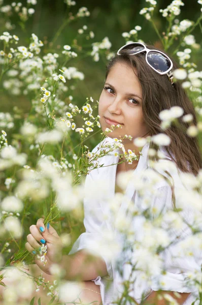 Fille assise entourée de marguerites — Photo