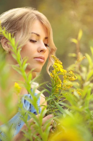 Beautiful caucasian girl smelling flowers — Stock Photo, Image