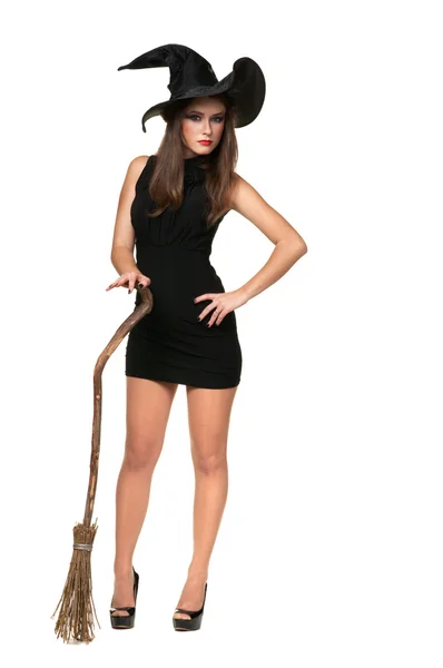 Pretty sexy young brunette witch with a broom — Stock Photo, Image