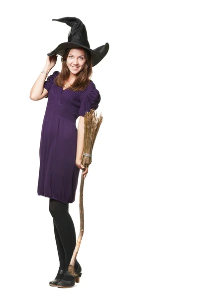 Молодая красивая ведьма в метле и шляпе — стоковое фото