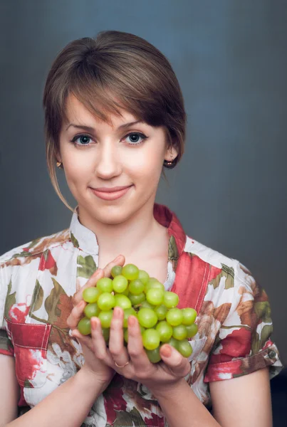 La chica está sosteniendo uvas frescas — Foto de Stock