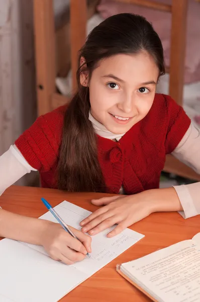 Mädchen macht Hausaufgaben in einem Notizbuch — Stockfoto