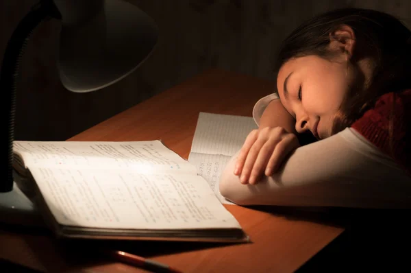 Dívka spí u stolu dělat domácí úkoly — Stock fotografie