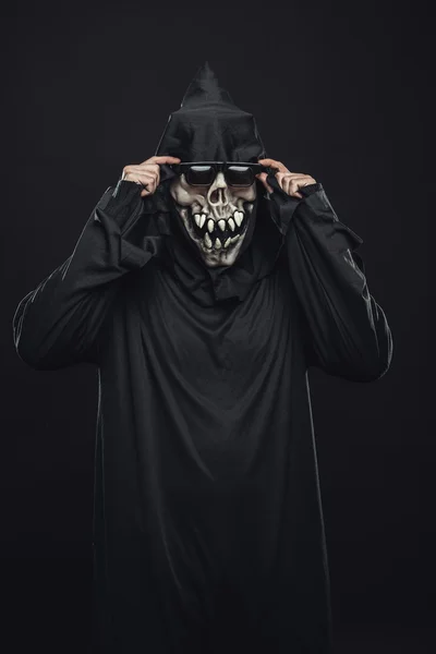 Скелет в чорному халаті виправляє окуляри — стокове фото