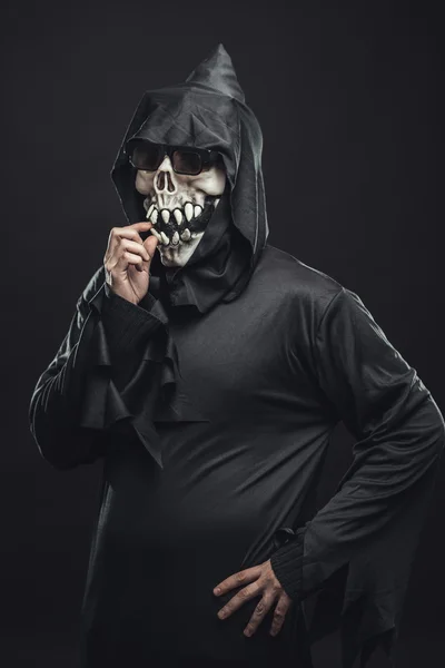 Esqueleto em um manto pega seus dentes — Fotografia de Stock