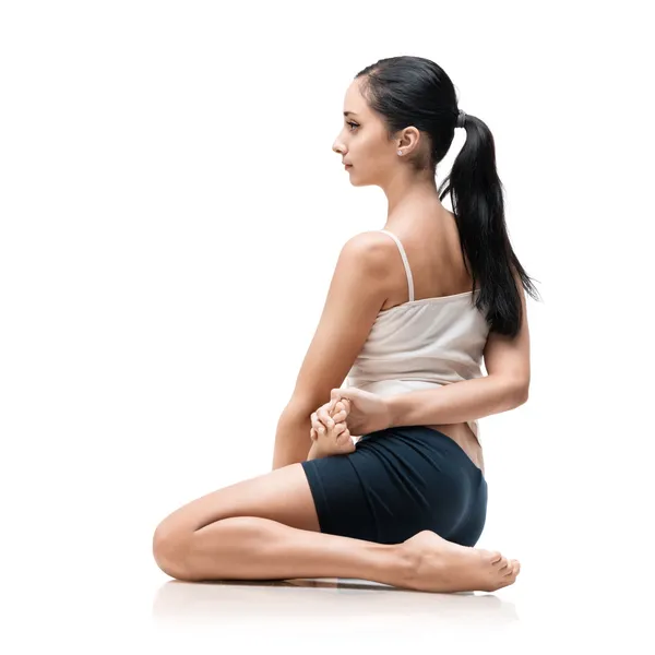 Женщина в позиции йоги бхарадвадзасаны — стоковое фото