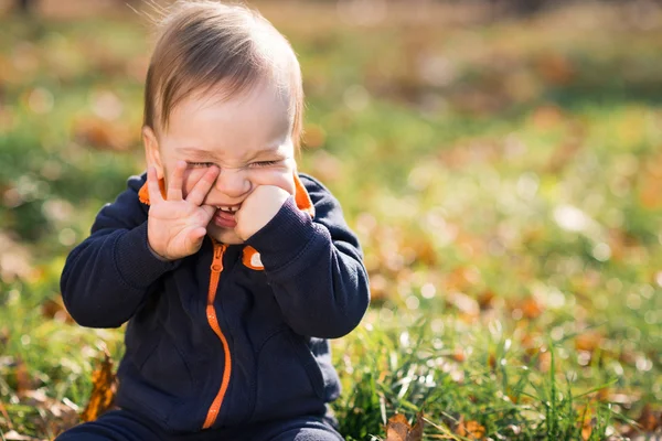 Ragazzo seduto sull'erba e martellante — Foto Stock