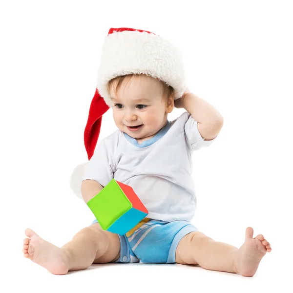 Criança de chapéu Papai Noel coça a cabeça — Fotografia de Stock