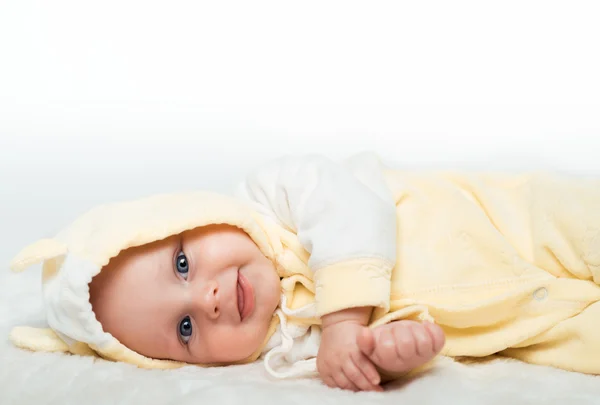 Lille baby smiler i gul skjorte – stockfoto